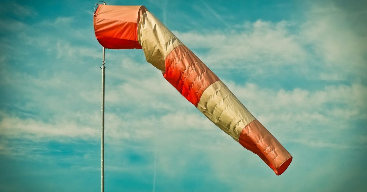 淄博天气信息导航站的编辑正在灯下对照多份公开气象资料，逐条核对当日气温与降水趋势，桌面摆着记录本和一杯热茶，窗外是深夜的城市灯光
